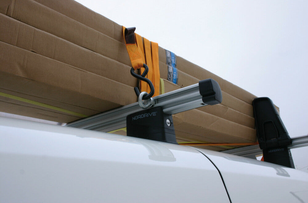 Œillets en acier renforcé pour barres aluminium, montrés en utilisation avec sangles pour maintenir charges longues sur galerie.